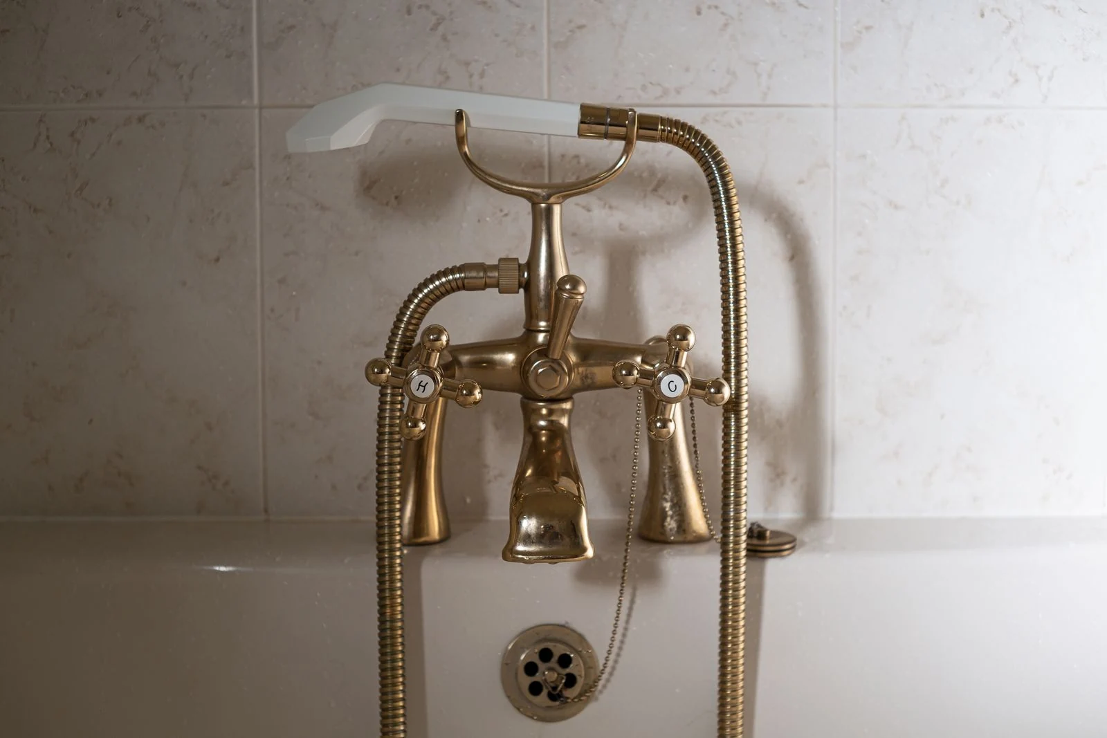 Close-up of a classic brass bathtub faucet with a ceramic hand shower in Greystoke, England