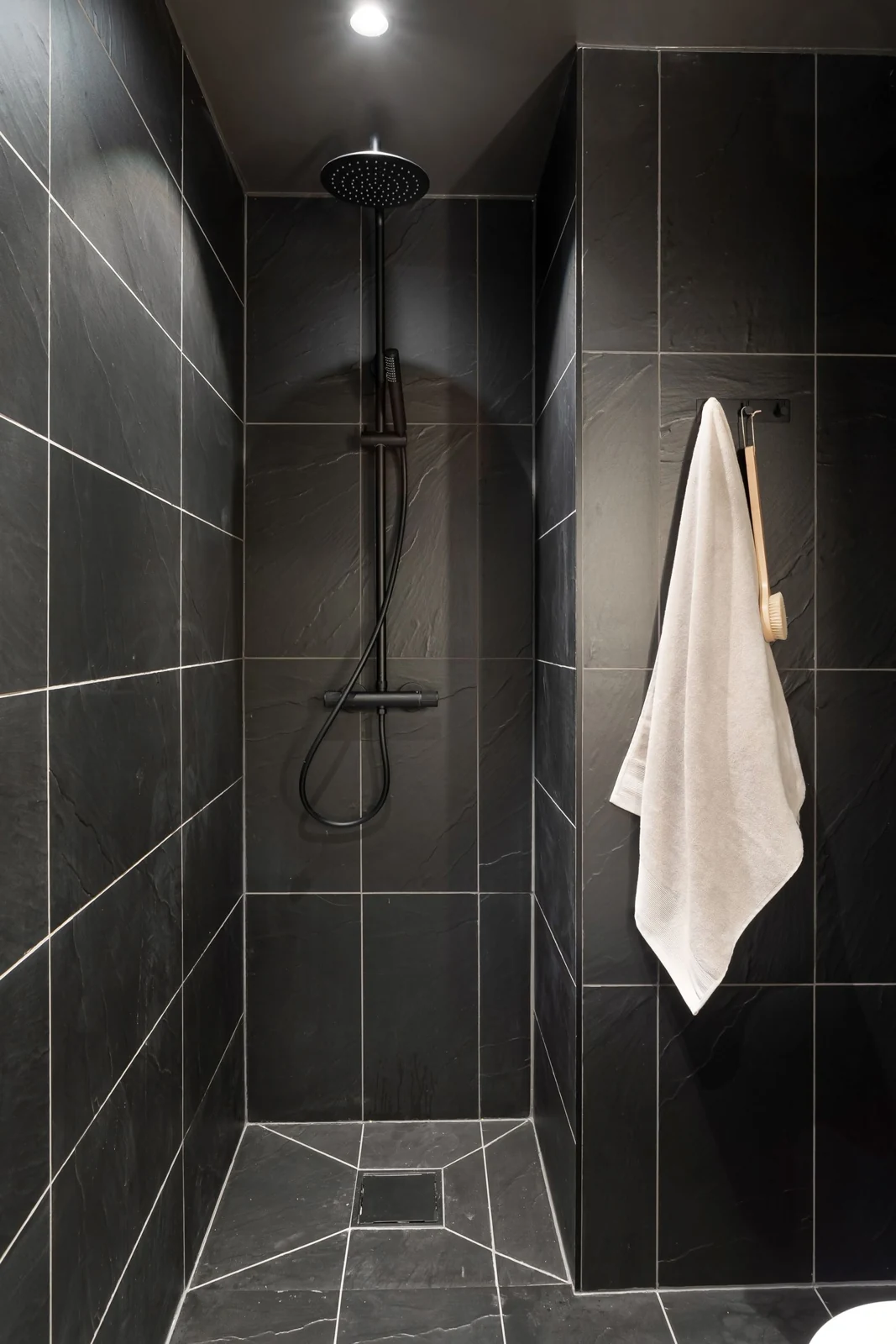 Tiled shower area with a hanging towel