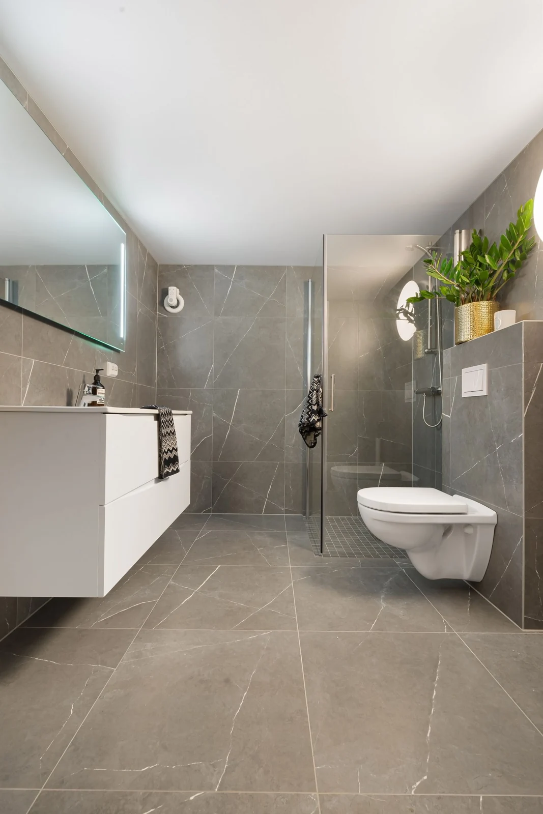 Elegant gray tile bathroom with a modern shower and washbasin setup