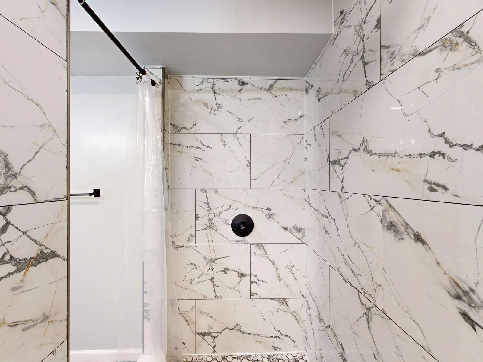 Luxurious modern shower with white and gray marble tiles and minimal design