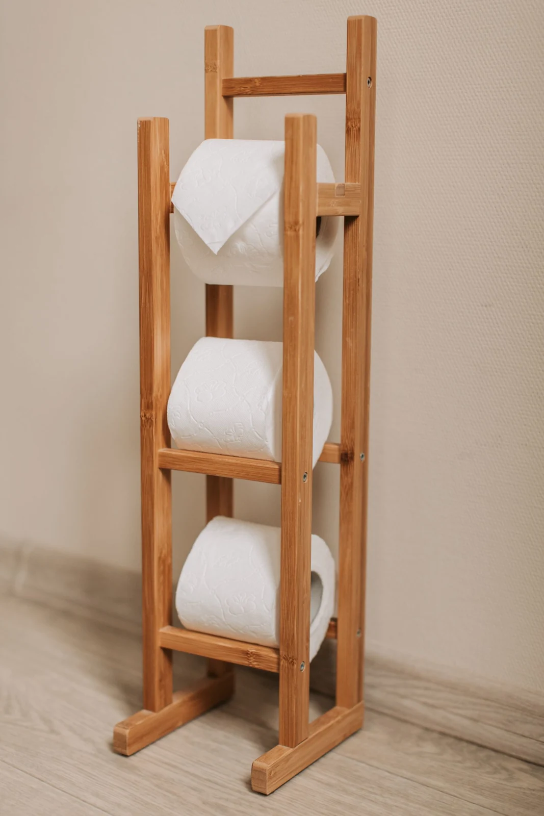 Wooden towel stand beside a bathroom wall