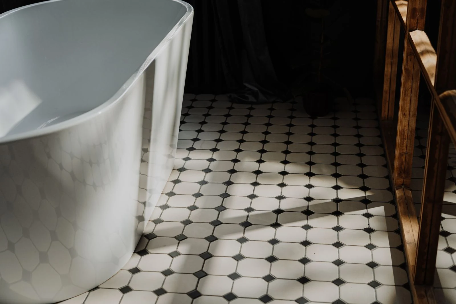 Small patterned floor tiles beside a bath