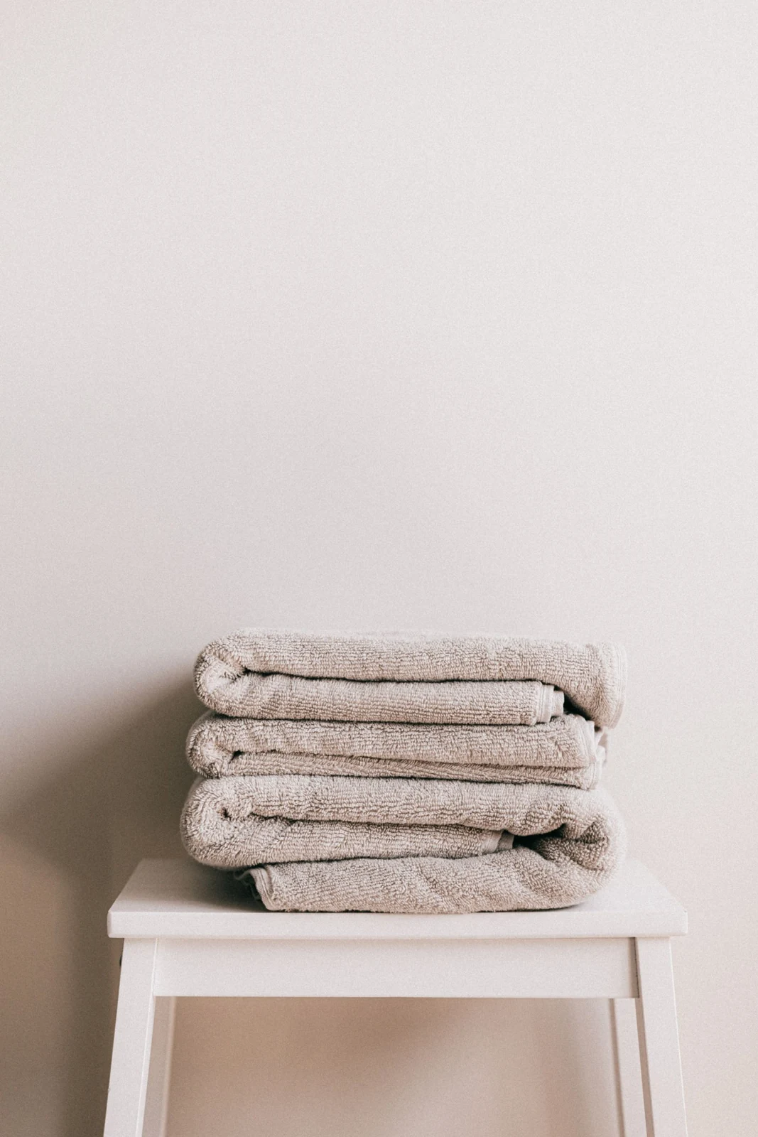 Folded towels on a small bathroom stool