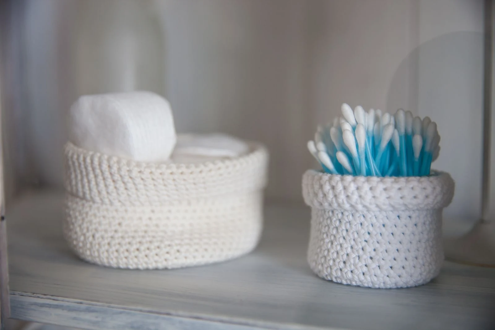 Small storage pots on a bathroom shelf