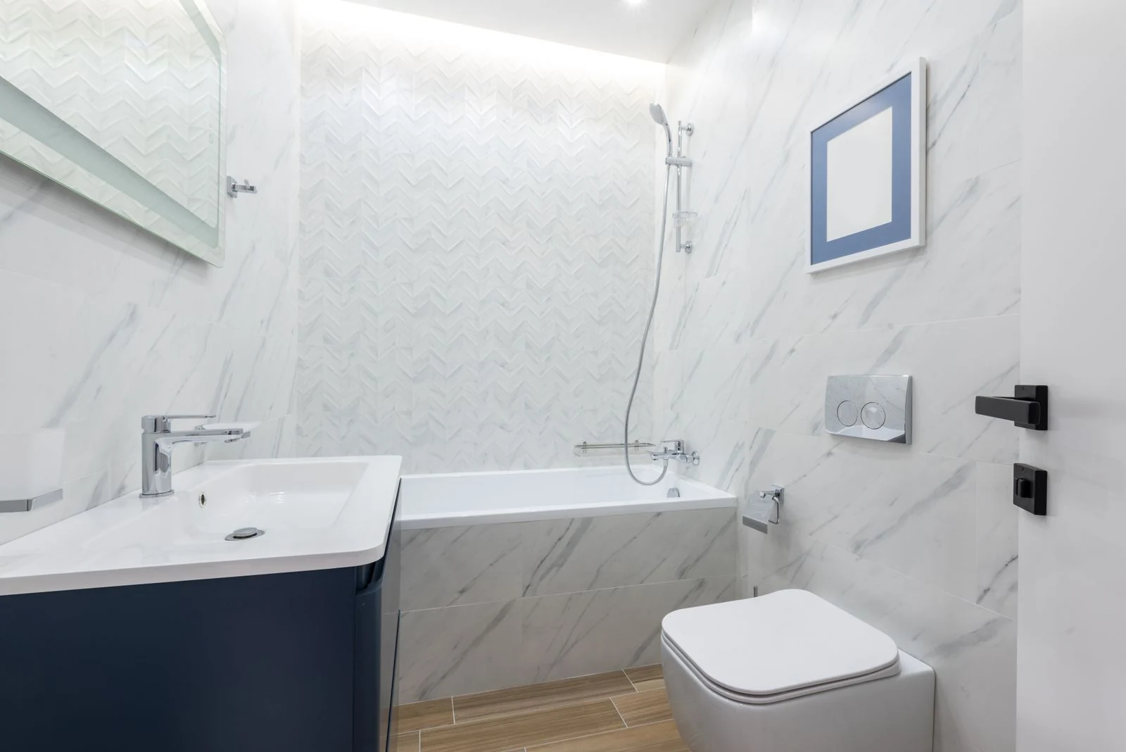 Modern light bathroom with tub placed near sink with faucet against white toilet at tiled wall near opened door at home