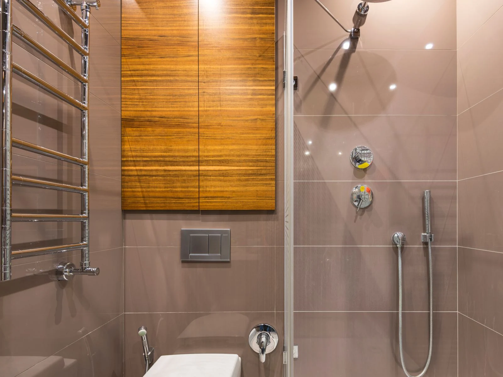 Elegant bathroom featuring a wooden cabinet, shower, and chrome fixtures, perfect for contemporary interiors